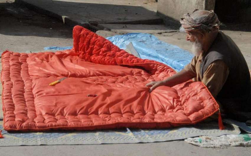 راولپنڈی: موسم سرد ہونے کے باعث ایک معمر شخص رضائی بنانے ..