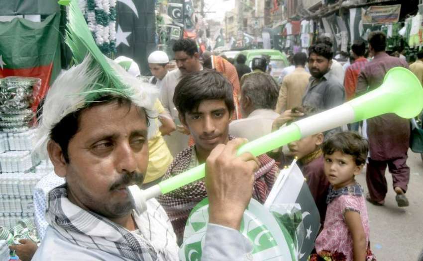 لاہور: ایک شخص اردو بازار میں یوم آزادی کی مناسبت سے چیزیں ..