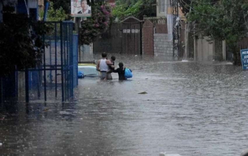 راولپنڈی: شدید بارش کے بعد ڈھوک کھبہ میں ایک شہری اپنے بچوں ..