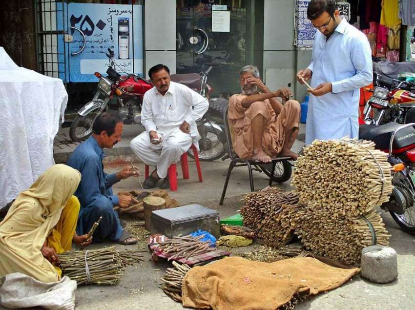 فیصل آباد: دکاندار فروخت کے لیے مسواکیں تیار کر رہاہے۔