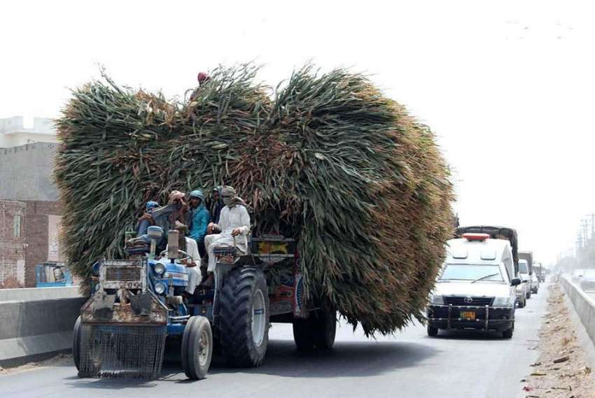 فیصل آباد: کسان ٹریکٹر ٹرالی اوولوڈ کیے جا رہے ہیں جو کسی ..