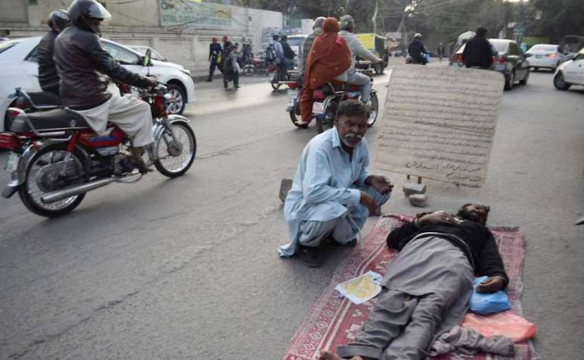 لاہور: مومن پورہ کا رہائشی شخص اپنے بیٹے کو پریس کلب کے باہر ..