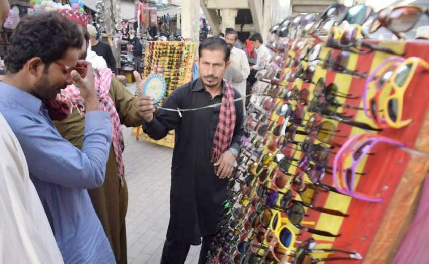 لاہور: سڑک کنارے لگے سٹال سے شہری عینکیں خرید رہے ہیں۔