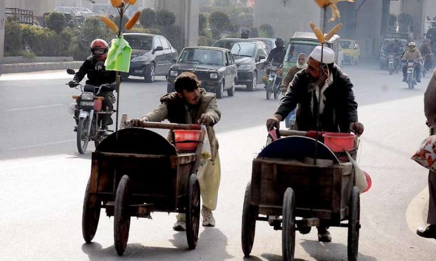 راولپنڈی: محنت کش اپنی ریڑھیوں کے ہمراہ مری روڈ سے گزر ر ..
