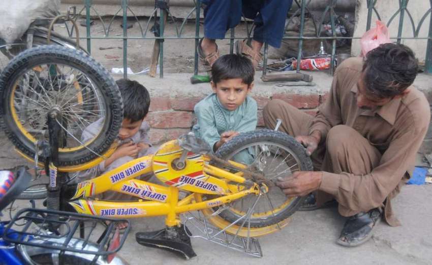 لاہور: نیلا گنبد میں ایک کاریگر سائیکل مرمت کر رہا ہے۔