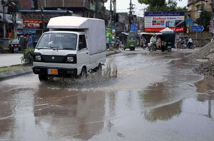 راولپنڈی: بارش کے بعد جمع پانی سی سوزوکی وین گزر رہی ہے۔