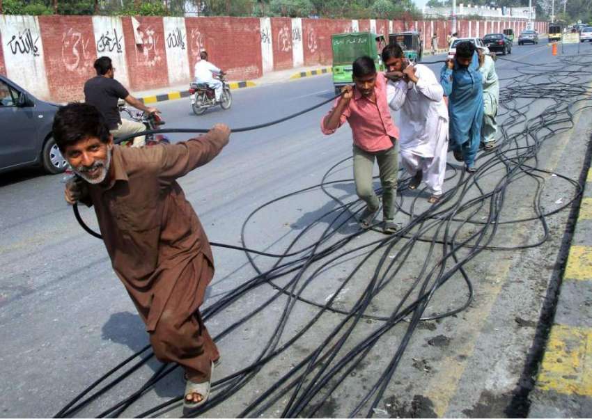 فیصل آباد: پی ٹی سی اہلکار جیل روڈ پر نئی تاریں بچھا رہے ہیں۔