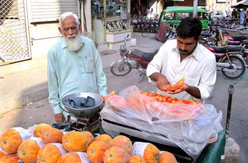 فیصل آباد: ریڑھی بان فروخت کے لیے پپیتا سجار ہاہے۔ 