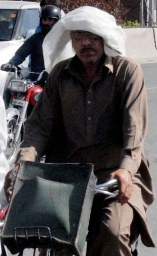 راولپنڈی: شدید گرمی میں دھوپ سے بچنے کے لیے سائیکل سوار سر ..