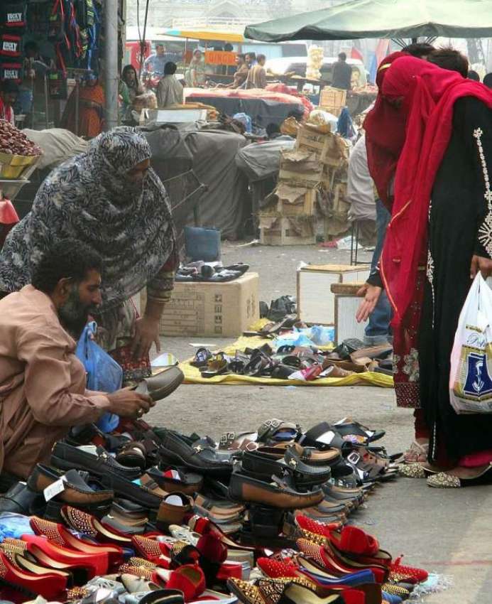 فیصل آباد: خواتین جھنگ بازار میں لگے سٹال سے جوتی خرید رہی ..