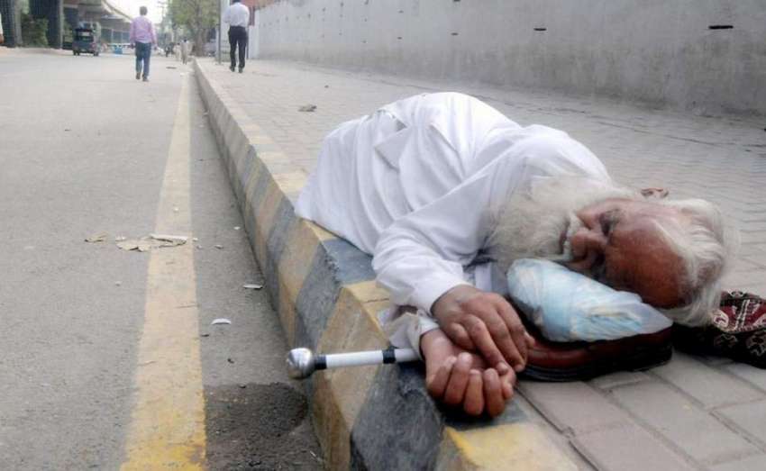 لاہور: ایک معمر بھکاری ڈیس سی آفس کے باہر فٹ پاتھ پر نیند ..