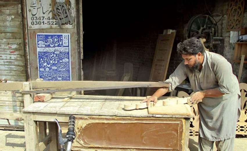 فیصل آباد: کارپینٹر اپنی ورکشاپ میں فرنیچر پر ڈیزائننگ کررہا ..