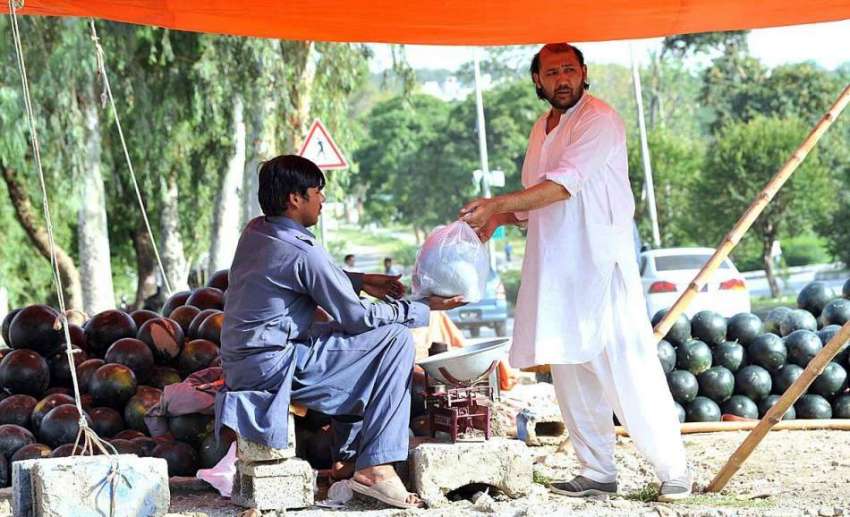 اسلام آباد: شہری سڑک کنارے لگے سٹال سے تربوز خرید رہا ہے۔