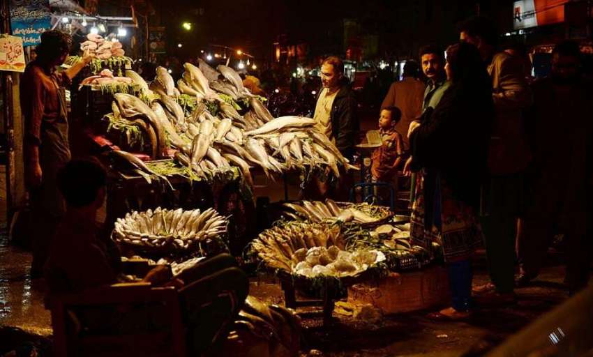 راولپنڈی: شہری سڑک کنارے لگے سٹال سے مچھلی خرید رہے ہیں۔