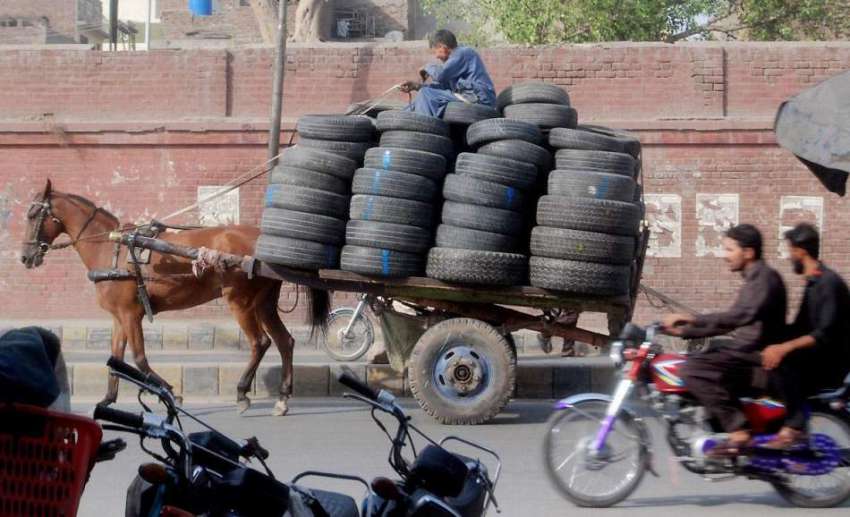 لاہور: محنت کش ریڑھے پر گاڑیوں کے پرانے ٹائر رکھ کر لیجا ..