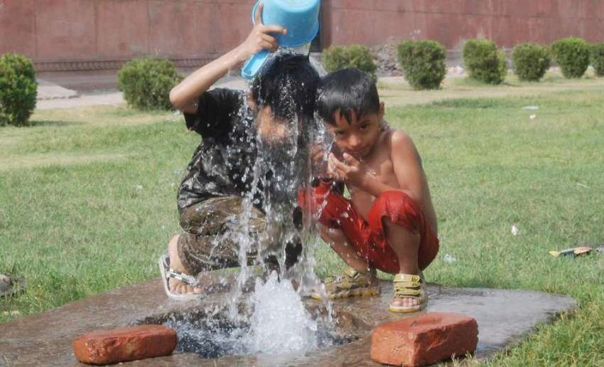 لاہور: پارک میں بچے گرمی کی شدت کم کرنے کے لیے نہا رہے ہیں۔