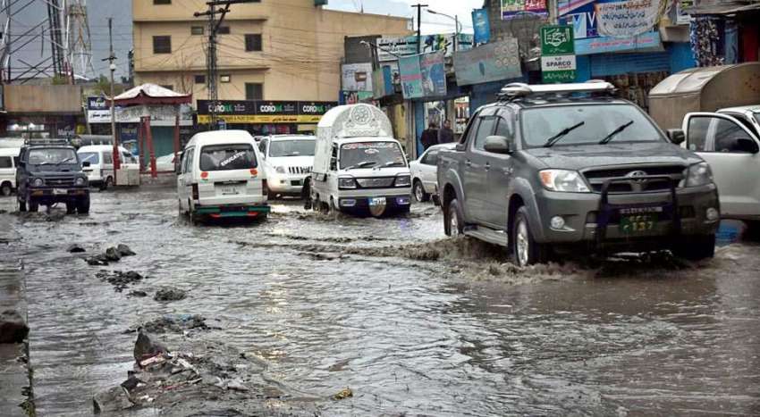 گلگت: موسلا دھار بارش کے بعد جمع پانی سے گاڑیاں گزر رہی ہیں۔