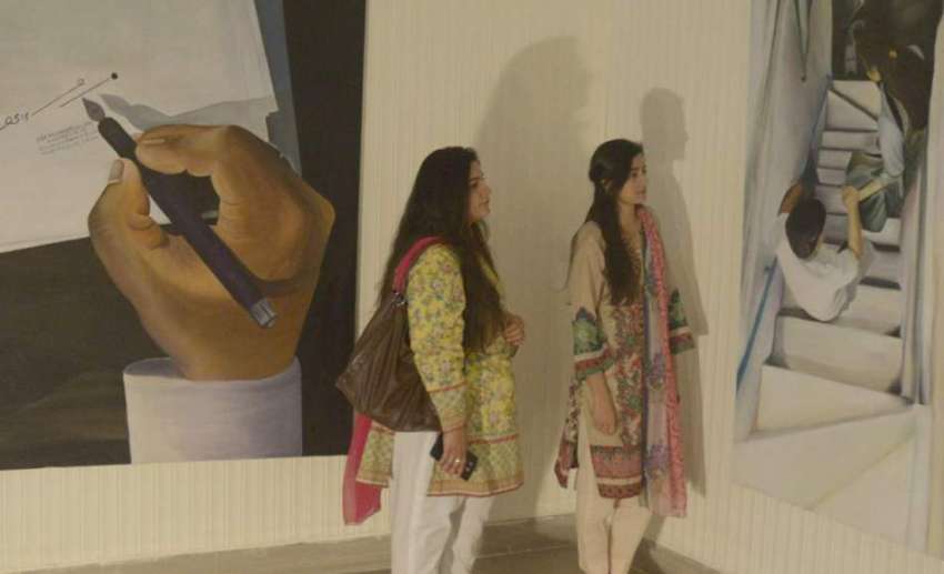 لاہور: ایک طالبات پینٹنگ کی نمائش دیکھ رہی ہیں۔