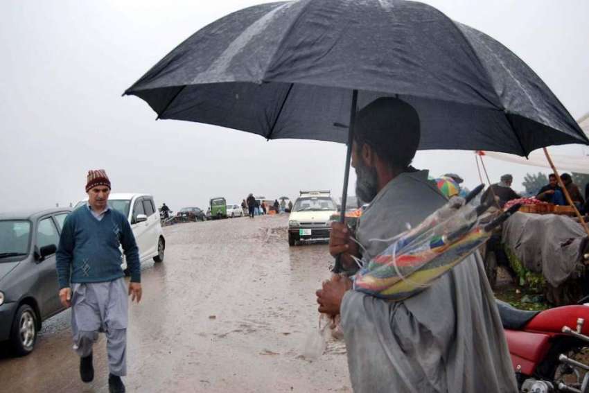 اسلام آباد: محنت کش سڑک کنارے چھتریاں فروخت کررہاہے۔