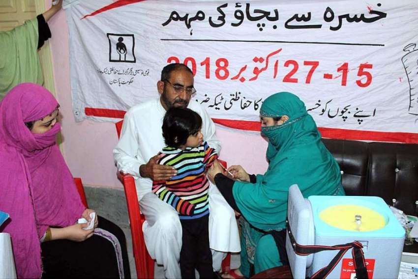 پشاور: انسداد خسرہ مہم کے دوران لیڈی ہیلتھ ورکر ایک بچی کے ..