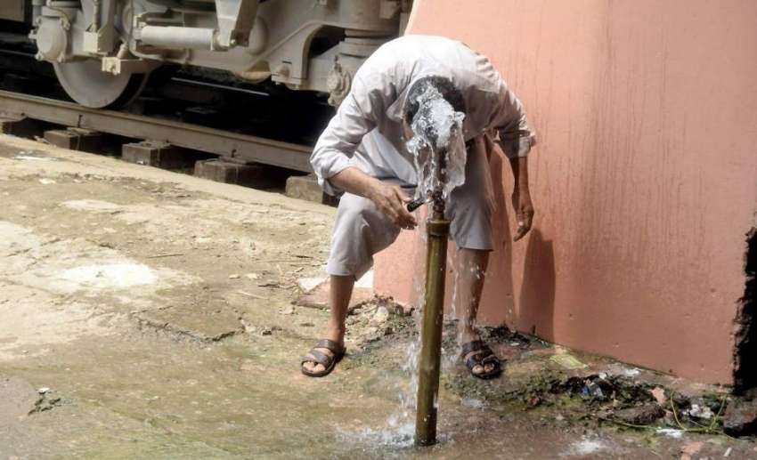 لاہور: ریلوے اسٹیشن پر ایک شخص گرمی کی شدت کم کرنے کے لیے ..