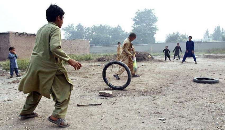 پشاور: خانہ بدوش بچے چار سدہ بائی پاس کے قریب کرکٹ کھیل رہے ..