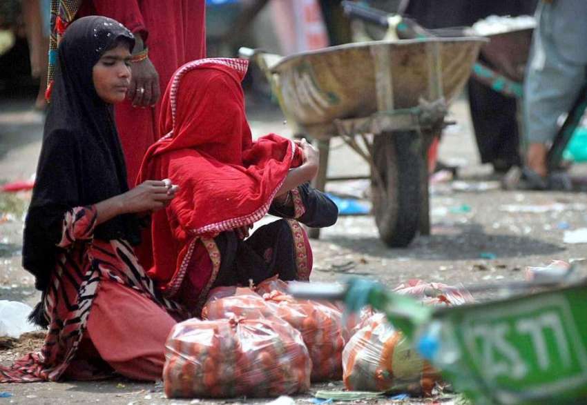 اسلام آباد: محنت کش خاتون سبزی منڈی میں پیاز فروخت کے لیے ..