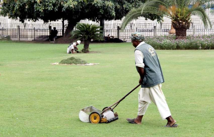 لاہور: پی ایچ اے کا ملازم سمٹ مینمار پارک میں گھاس کاٹ رہا ..