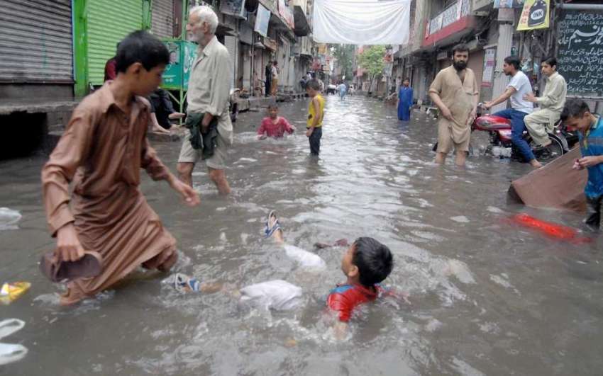 راولپنڈی: امر پورہ میں بچے بارش کے پانی میں نہار ہے ہیں۔