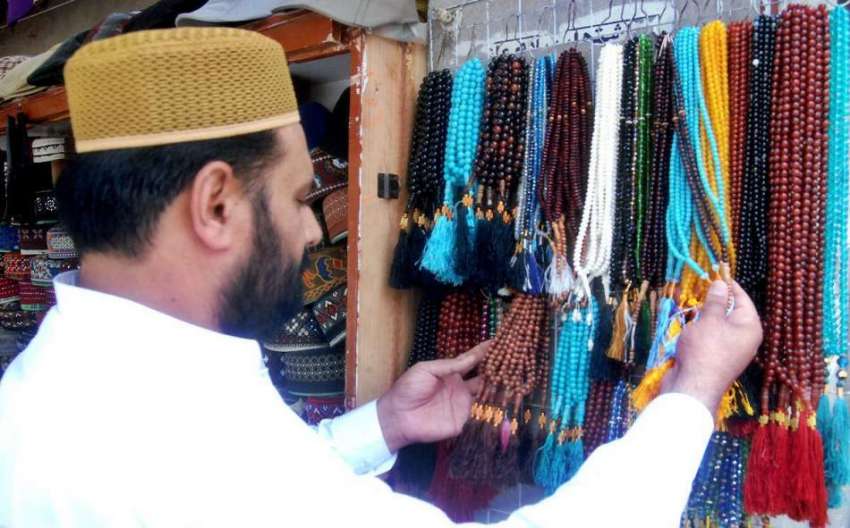 لاہور: ایک شہری مال روڈ پر مسجد شہداء کے باہر دکان سے تسبیح ..