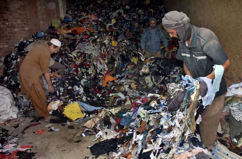 پشاور: مزدور کپڑے کے کارآمد پیس اکٹھے کر رہے ہیں۔