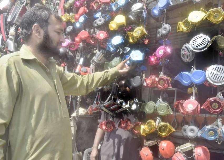 لاہور: ایک شہری اپنی موٹر سائیکل پر لگانے کے لئے ہارن خرید ..