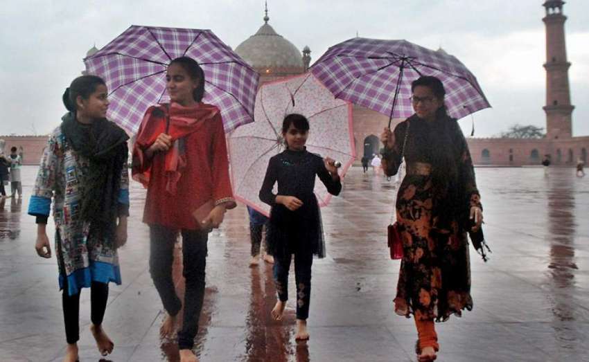 لاہور: بارش کے دوران بادشاہی مسجد میں بچیاں چھتریاں تانے ..
