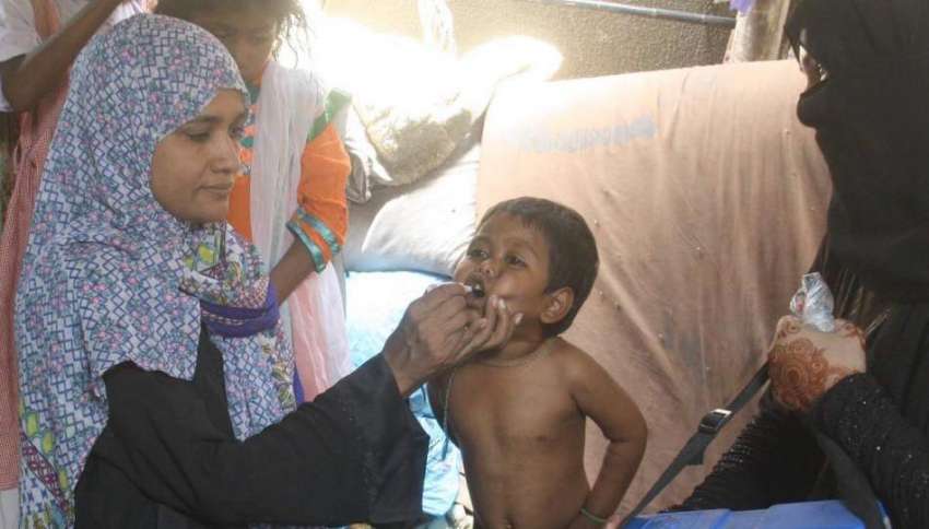 کراچی: انسداد پولیو مہم کے دوران لیڈی پولیو ورکر ایک بچے ..