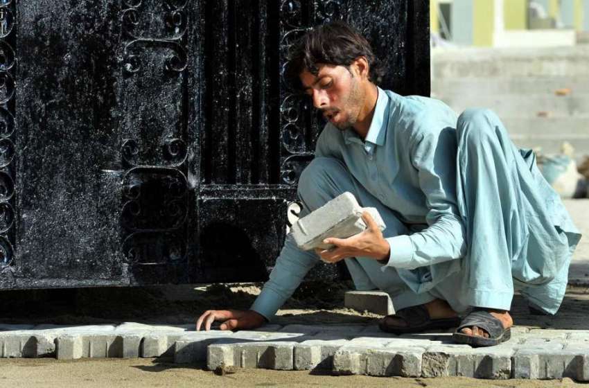 اسلام آباد: وفاقی دارالحکومت میں ایک مزدور فٹ پاتھ پر ٹائلیں ..