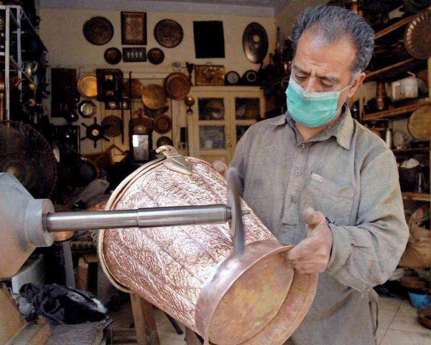 راولپنڈی: محنت کش پرانے برتنوں کو کلی کرنے میں مصروف ہے۔