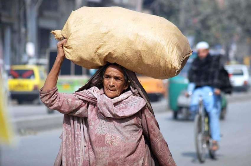 پشاور: ایک معمر خاتون سر پر سامان بھرا تھیلا اٹھائے اپنی ..