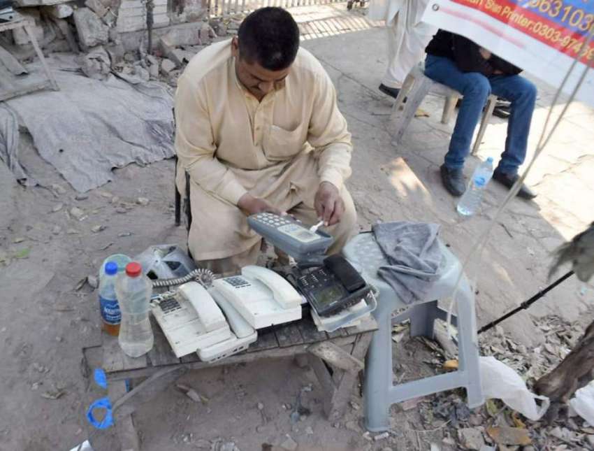 لاہور: ایک کاریگر ٹیلیفون مرمت کررہا ہے۔