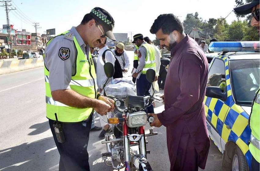 پشاور: ٹریفک وارڈن موٹر سائیکل سے ایل ای ڈی لائٹ اتا رہا ..