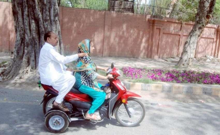 لاہور: ایک خاتون موٹر سائیکل پر جا رہی ہے۔