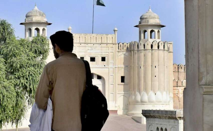 لاہور: ایک طالبعلم باشاہی مسجد کی بالکونی سے شاہی قلعے کا ..