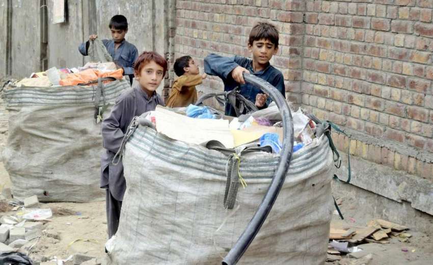 لاہور: بچے کباڑ خانے میں چھانٹی کئے گئے مال کو بورے میں ڈال ..
