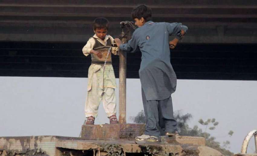 لاہور: دریائے راوی کنارے آباد خانہ بدوش بچے ہینڈ پمپ سے پانی ..
