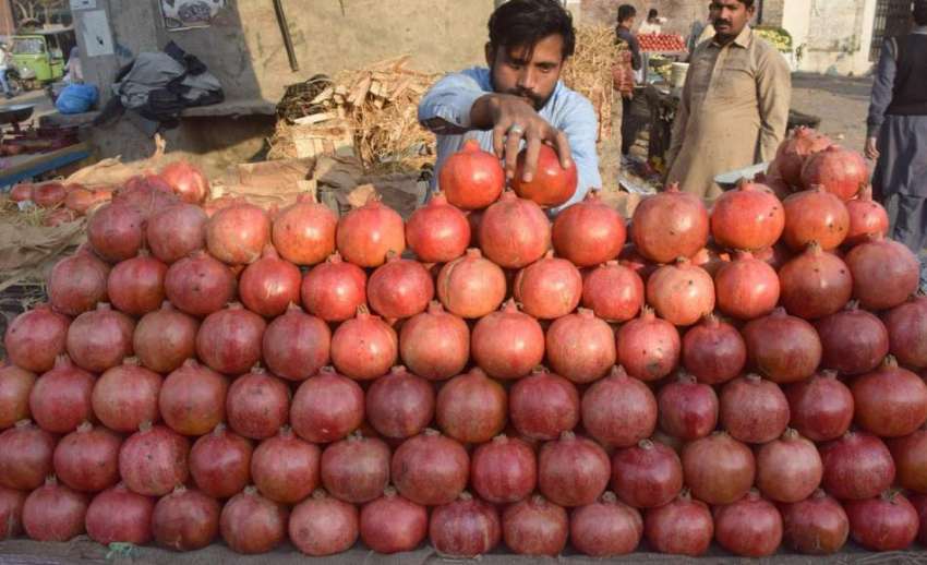 لاہور: ایک شخص انار فروخت کنے کے لیے ریڑھی پر سجارہاہے۔