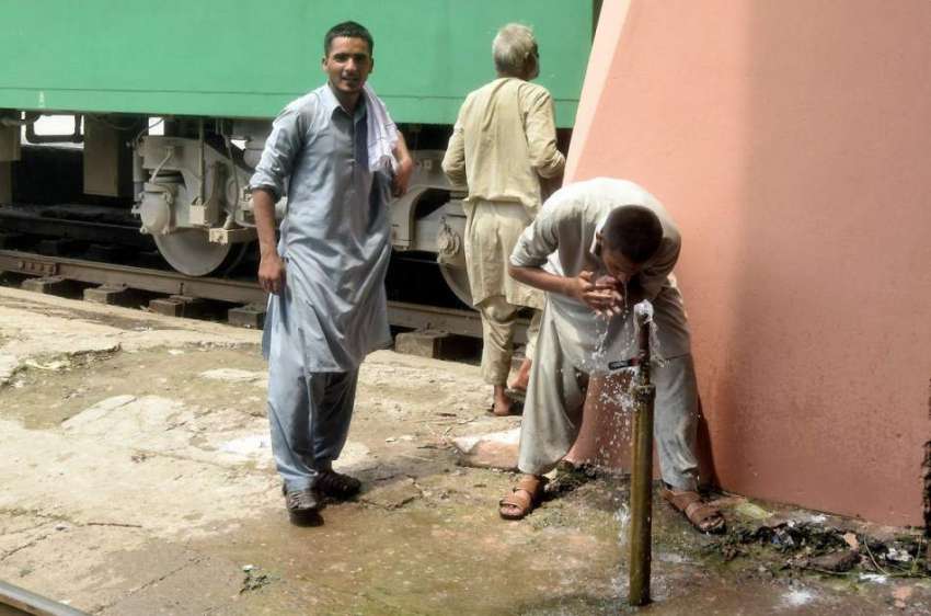 لاہور: ریلوے اسٹیشن پر ایک شخص پیاس بجھانے کے لیے پانی پی ..