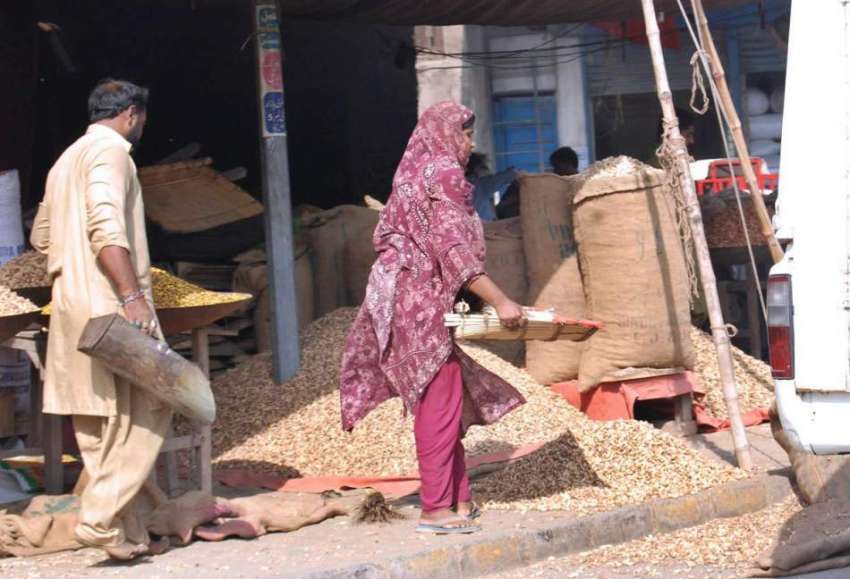 فیصل آباد: محنت کش خاتون مونگ پھلی کی صفائی ستھرائی کرنے ..