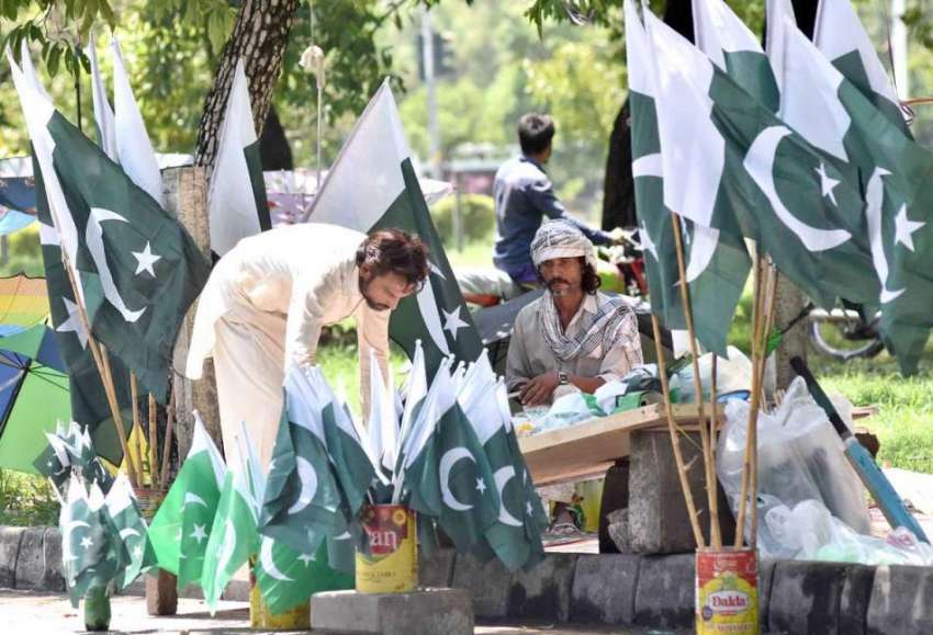 اسلام آباد: وفاقی دارالحکومت میں ایک دکاندار سڑک کنارے قومی ..