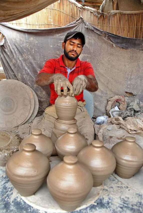 حیدر آباد: ایک کمہار روایتی انداز سے مٹی کی اشیاء بنانے میں ..