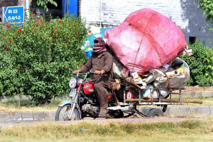 اسلام آباد: ایک شخص چنگچی موٹر سائیکل پر اوورلوڈنگ کیے جارہا ..