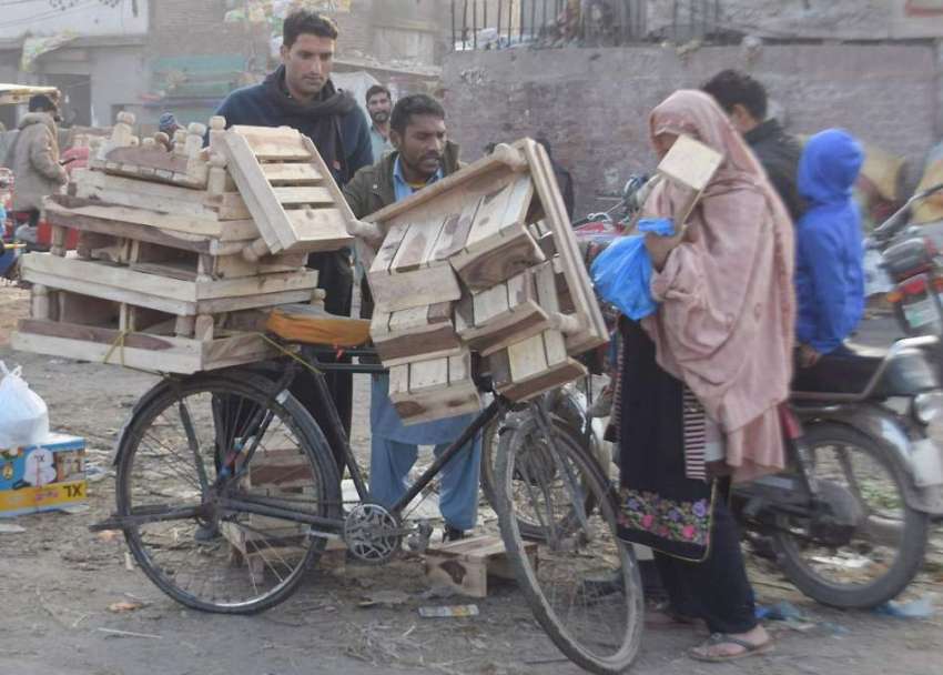 لاہور: ایک محنت کش لکڑی کی چوکیاں فروخت کررہا ہے۔